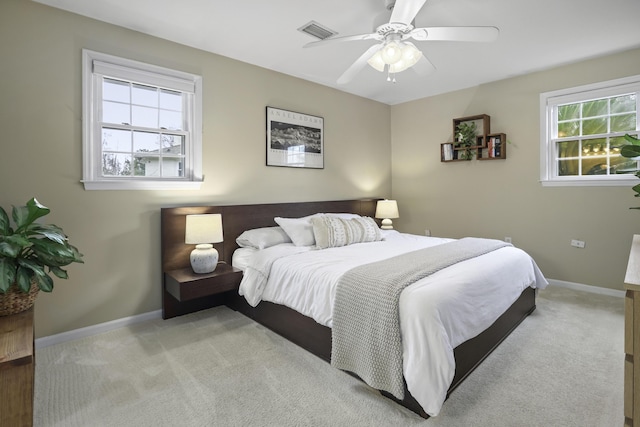 carpeted bedroom with ceiling fan and multiple windows