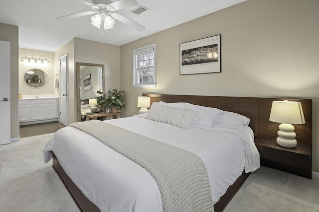 bedroom with ensuite bath, ceiling fan, and carpet