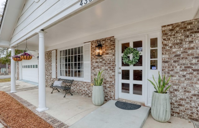 property entrance featuring a porch and a garage