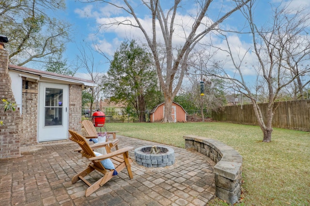 view of patio featuring an outdoor fire pit, a storage shed, and area for grilling