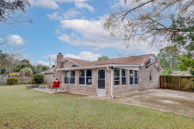 rear view of property featuring a yard, a fire pit, and a patio