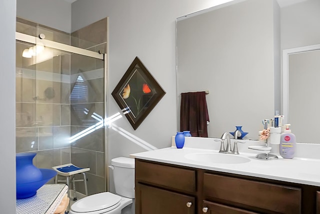 bathroom featuring a shower with door, vanity, and toilet