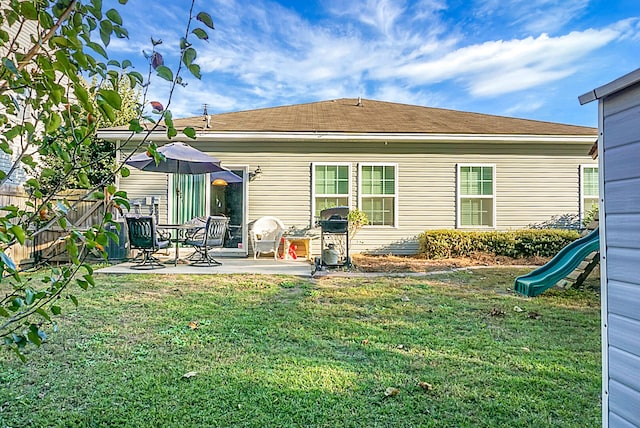 rear view of house with a yard and a patio area