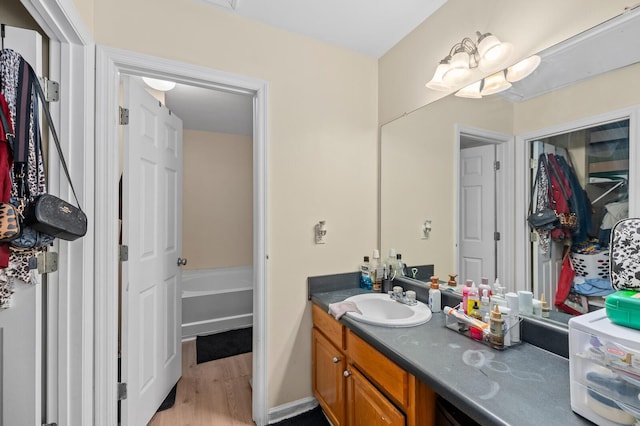 bathroom featuring vanity, hardwood / wood-style floors, and a washtub