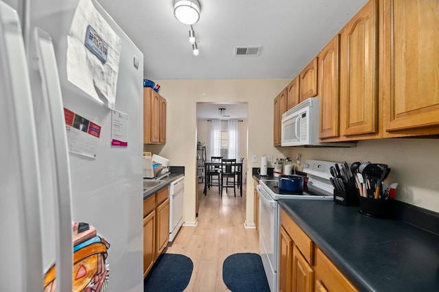 kitchen featuring white appliances and light hardwood / wood-style floors