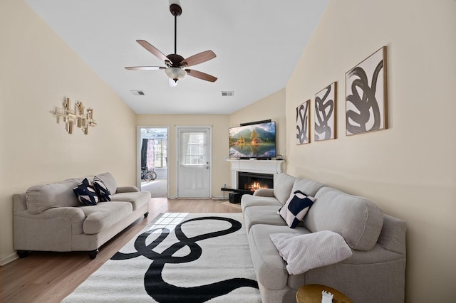 living room with ceiling fan, lofted ceiling, and light hardwood / wood-style floors