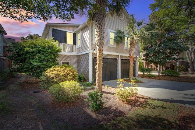property exterior at dusk with concrete driveway and a garage