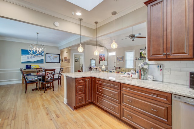 kitchen with light stone countertops, light wood-style flooring, a peninsula, decorative light fixtures, and stainless steel dishwasher