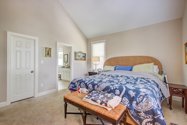 bedroom with high vaulted ceiling, light carpet, baseboards, and ensuite bath