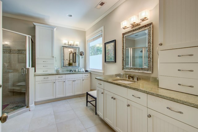 bathroom with visible vents, a shower stall, two vanities, a sink, and ornamental molding