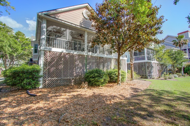 rear view of house with a yard, a ceiling fan, and a sunroom