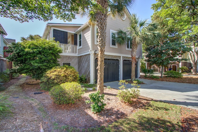 view of property exterior featuring a garage and concrete driveway