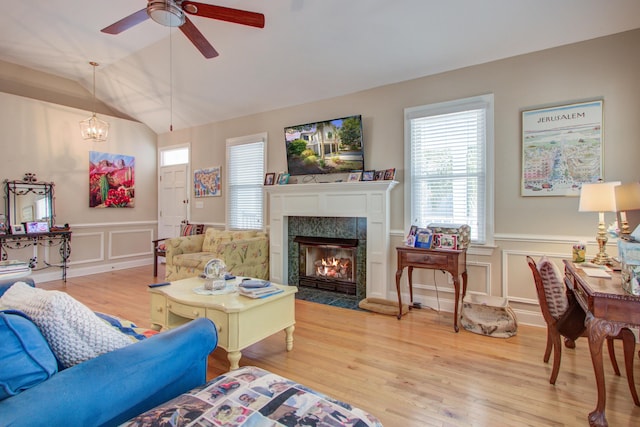 living area featuring wood finished floors, a decorative wall, a wealth of natural light, and a fireplace