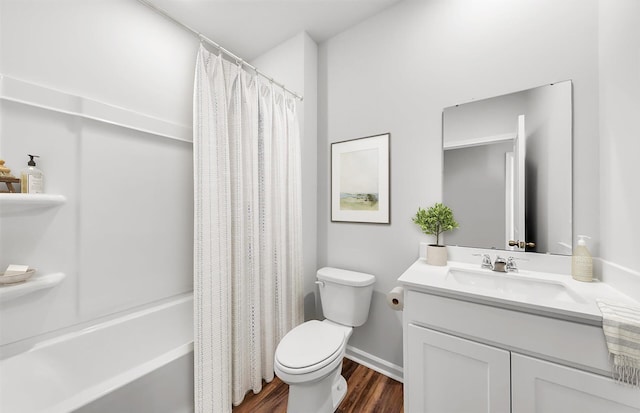 bathroom with vanity, wood finished floors, baseboards, shower / bath combo with shower curtain, and toilet