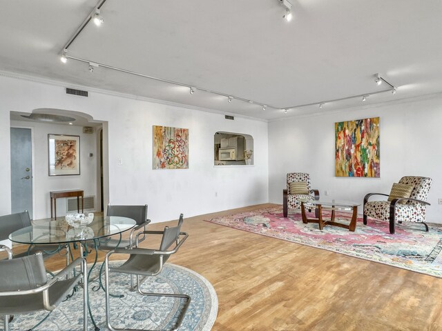 dining room with wood-type flooring and ornamental molding