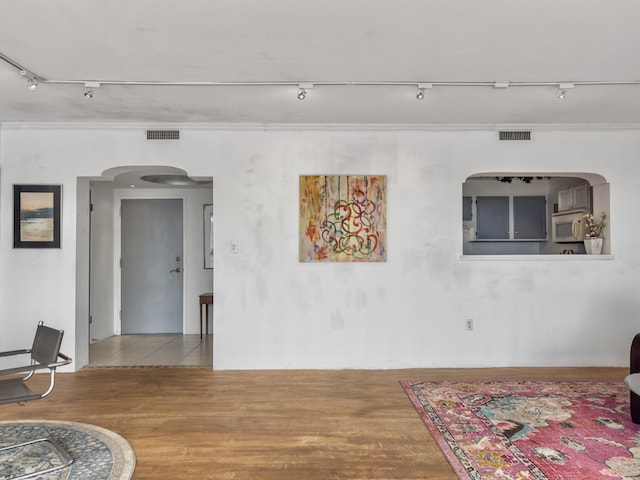 interior space with hardwood / wood-style floors and crown molding