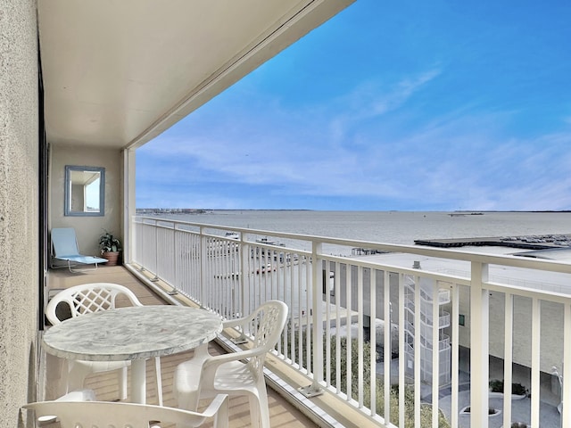 balcony featuring a view of the beach and a water view