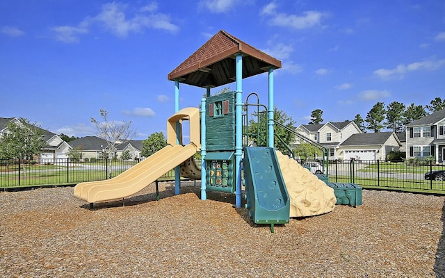 community playground featuring fence and a residential view