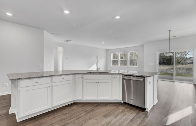 kitchen featuring dishwasher, a sink, wood finished floors, stone counters, and recessed lighting