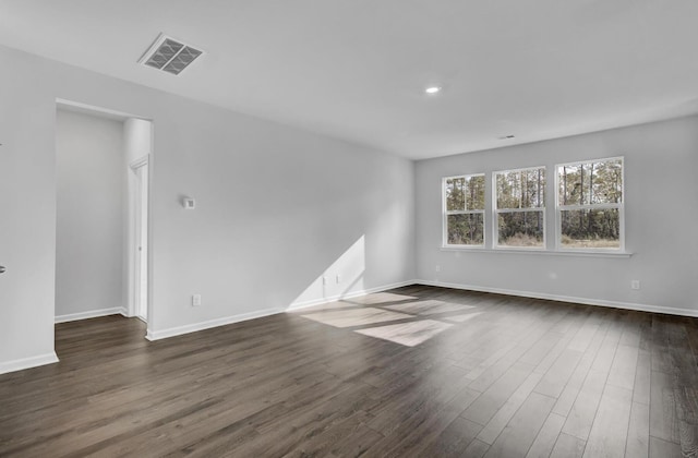empty room with dark wood-style floors, baseboards, and recessed lighting