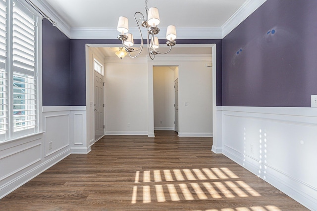 unfurnished dining area featuring a chandelier, ornamental molding, and dark wood-type flooring