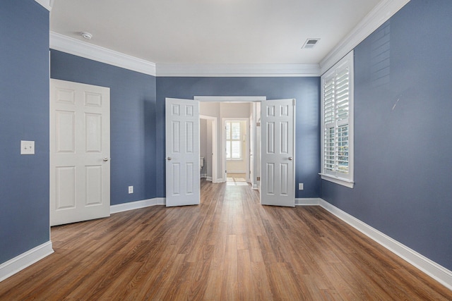 unfurnished bedroom with crown molding and dark hardwood / wood-style flooring