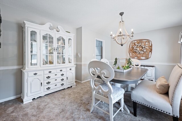 dining room with light carpet, a chandelier, and a textured ceiling