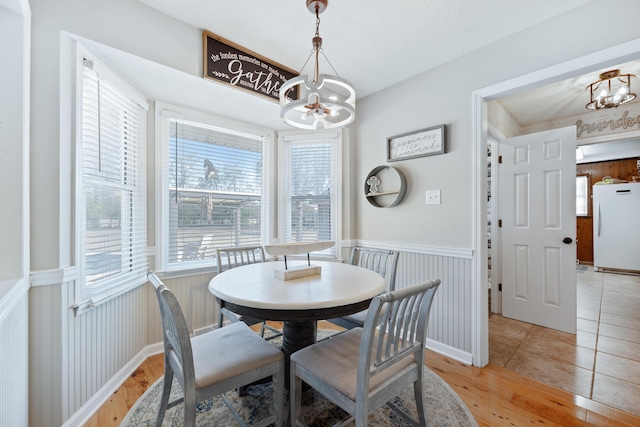 tiled dining room featuring a chandelier and a textured ceiling