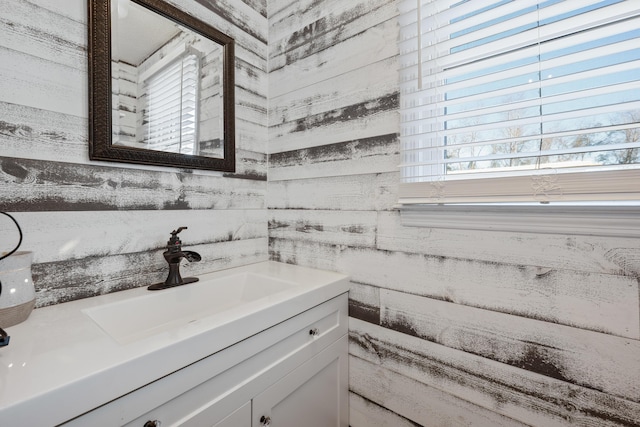 bathroom with vanity and wooden walls