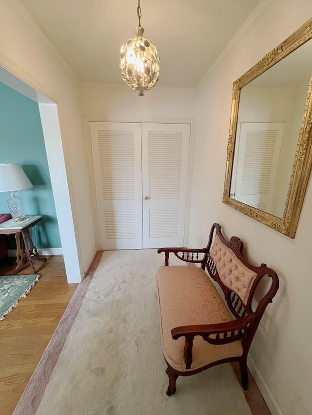 living area featuring light wood-type flooring, crown molding, and a notable chandelier