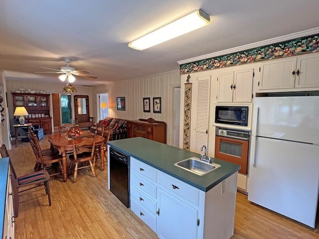 kitchen featuring sink, white cabinets, black appliances, and light hardwood / wood-style floors