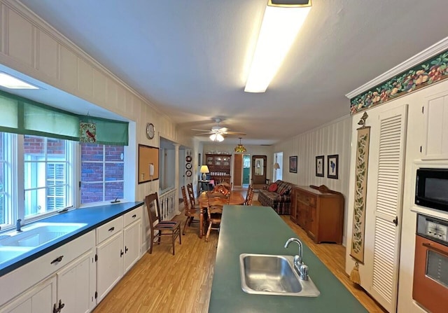 kitchen with white cabinets, stainless steel oven, black microwave, and sink