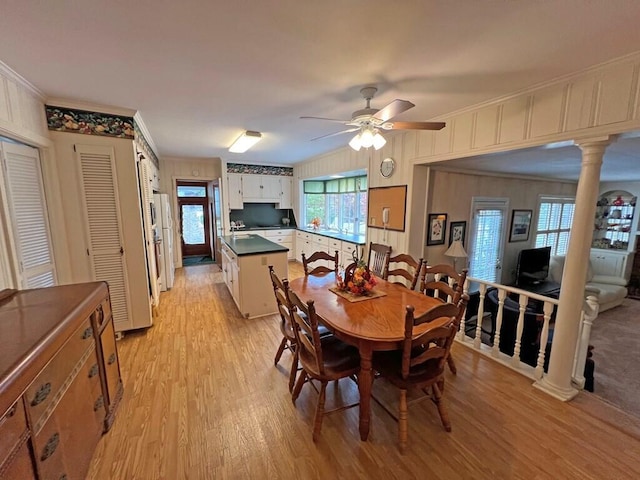 dining area featuring ornate columns, ceiling fan, crown molding, and light hardwood / wood-style floors