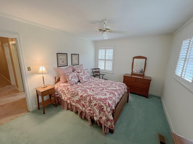 carpeted bedroom featuring ceiling fan and crown molding