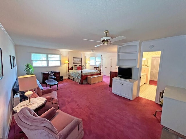 carpeted bedroom featuring ensuite bathroom, ceiling fan, and ornamental molding