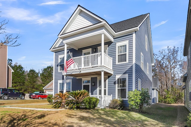 view of front of home featuring a porch, a front lawn, and a balcony