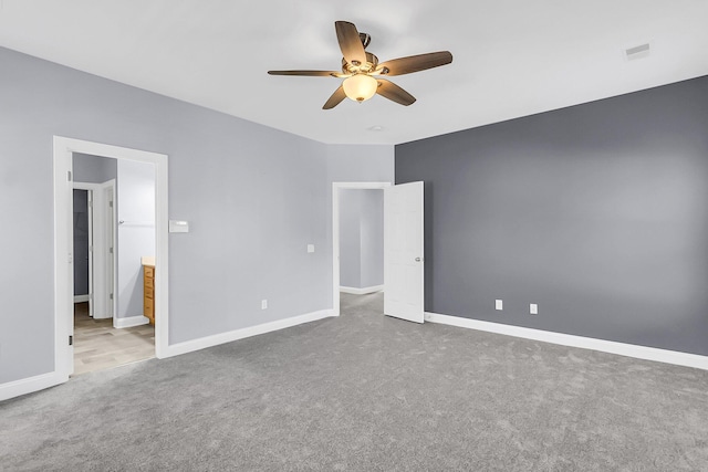 unfurnished bedroom featuring a ceiling fan, visible vents, baseboards, ensuite bath, and carpet flooring