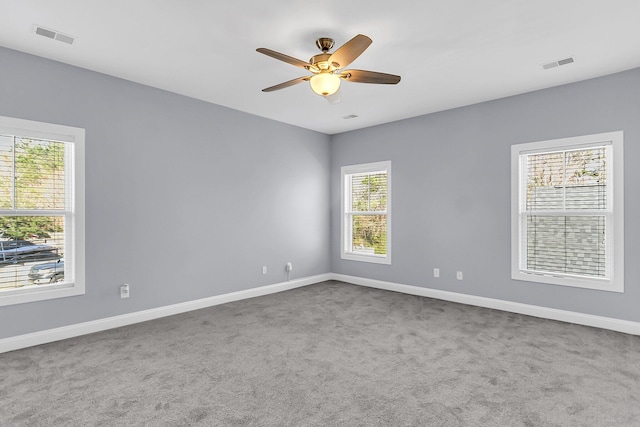 unfurnished room featuring visible vents, baseboards, carpet floors, and ceiling fan