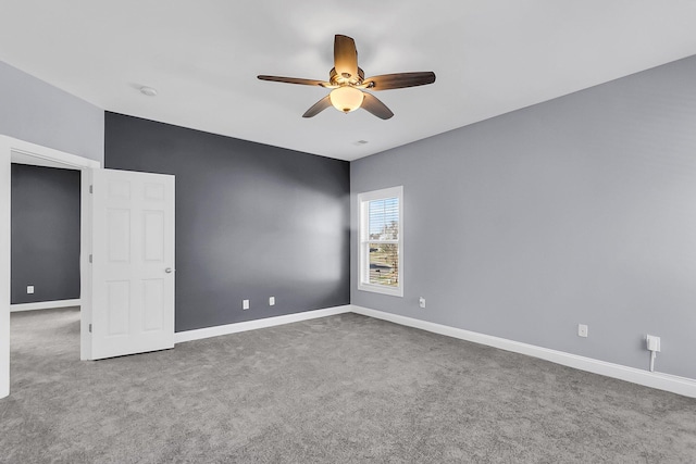 spare room with carpet flooring, baseboards, and ceiling fan