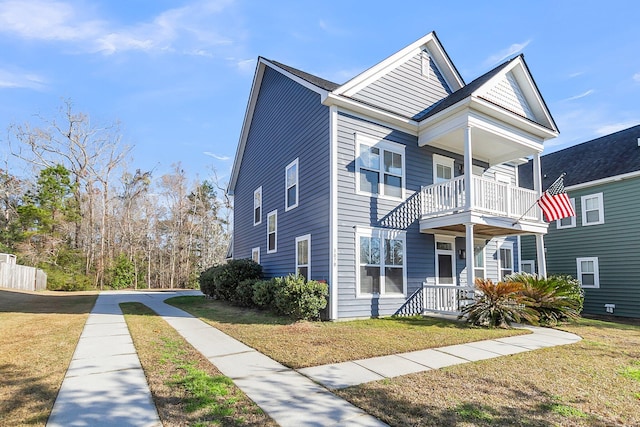 view of front of home featuring a balcony and a front yard