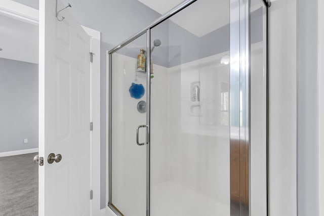 full bathroom featuring a shower stall and baseboards