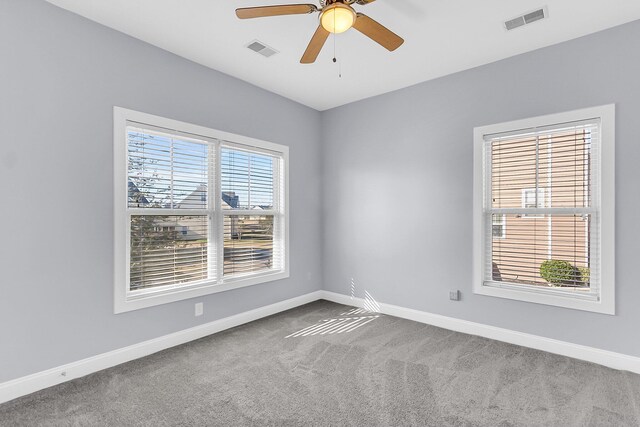 spare room with visible vents, plenty of natural light, and carpet