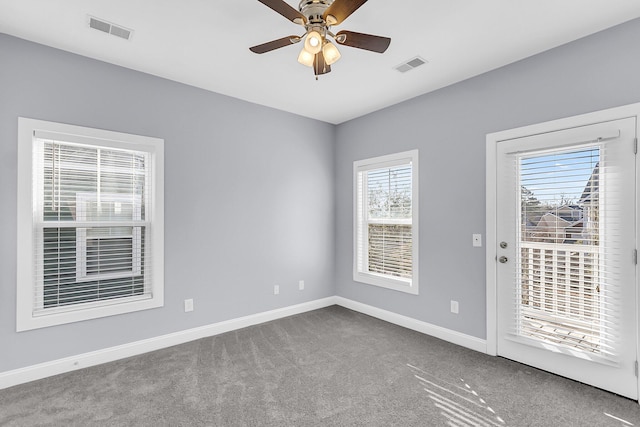 unfurnished room with visible vents, carpet flooring, a ceiling fan, and baseboards