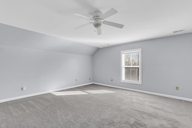 unfurnished room with visible vents, baseboards, vaulted ceiling, carpet flooring, and a ceiling fan