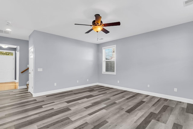 unfurnished room featuring visible vents, a ceiling fan, baseboards, and wood finished floors