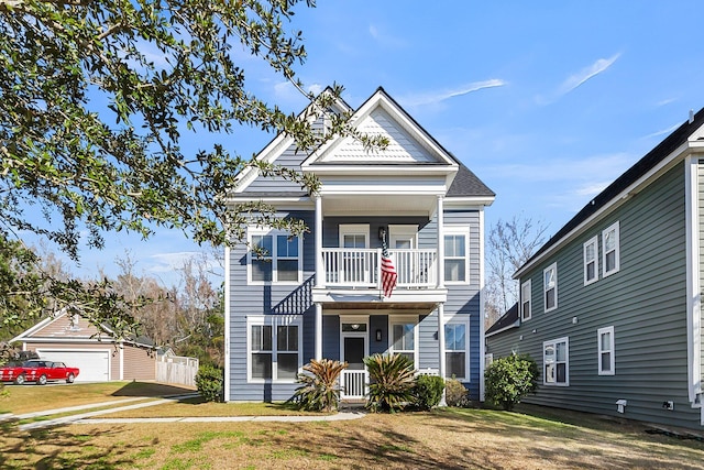 view of front of house featuring a balcony, a porch, and a front yard