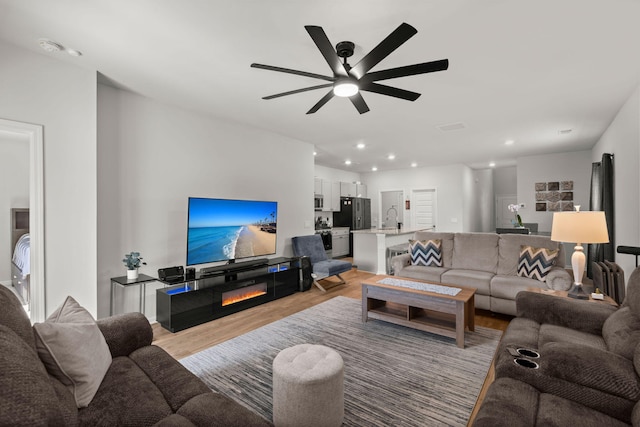 630 Jancus St, Charleston, SC 29414 - living area featuring light wood-style floors, a glass covered fireplace, a ceiling fan, and recessed lighting
