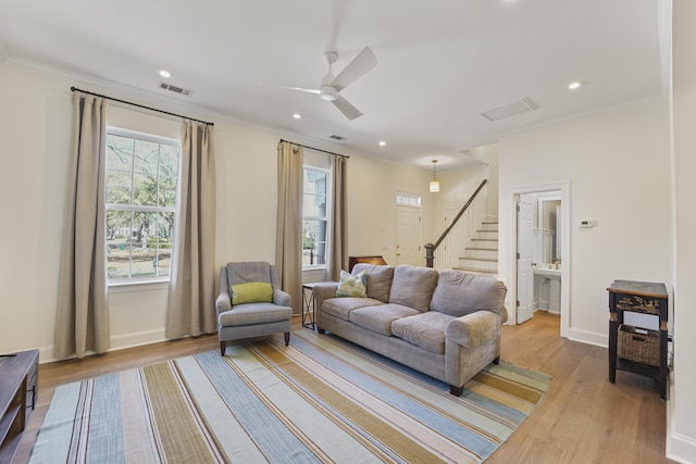 living area featuring stairs, wood finished floors, visible vents, and a wealth of natural light