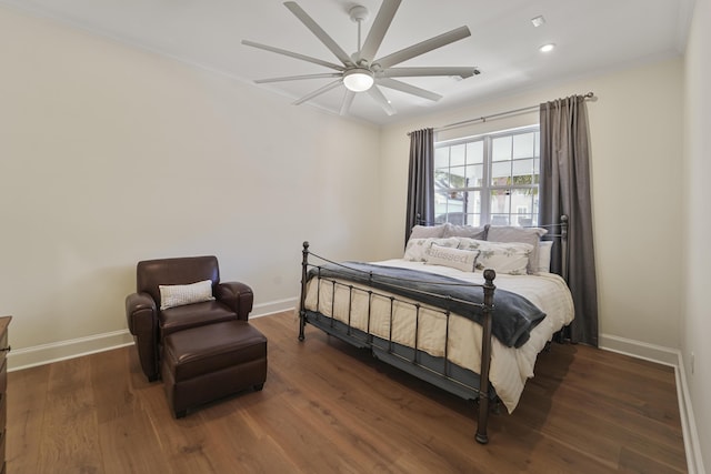 bedroom featuring baseboards, wood finished floors, and crown molding