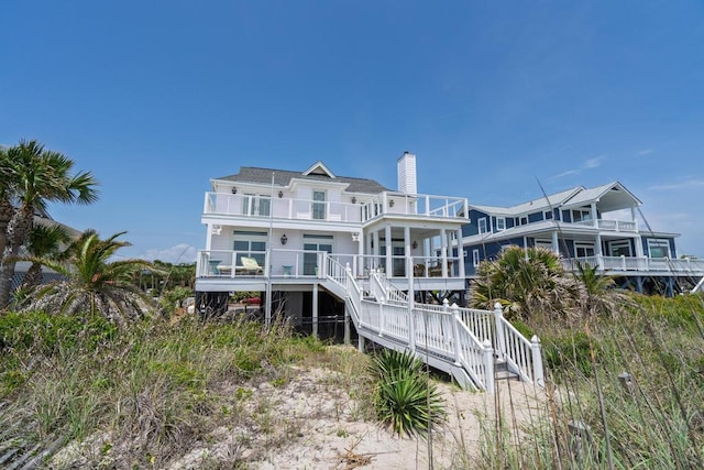1404 Palmetto Blvd, Edisto Beach, SC 29438 - back of house featuring stairway, a chimney, and a balcony